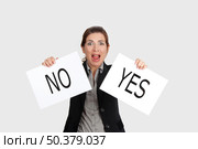 Business young woman trying to make a decision between Yes or No choice. Стоковое фото, агентство Ingram Publishing / Фотобанк Лори