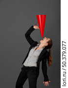 Business young woman speaking to a megaphone, over a grey background. Стоковое фото, агентство Ingram Publishing / Фотобанк Лори