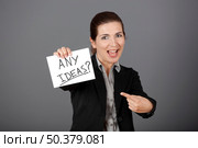 Business woman holding a card board with the text message "Hire me", focus is on the cardboard. Стоковое фото, агентство Ingram Publishing / Фотобанк Лори