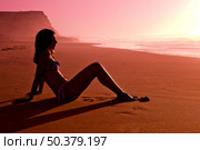 Female silhouette of a beautiful young girl on the beach at the sunset. Стоковое фото, агентство Ingram Publishing / Фотобанк Лори