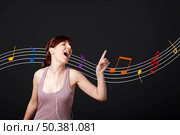 Happy young woman listen music and dancing, with musical notes in the background. Стоковое фото, агентство Ingram Publishing / Фотобанк Лори