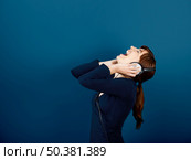 Happy young woman singing and listen music with headphones. Стоковое фото, агентство Ingram Publishing / Фотобанк Лори
