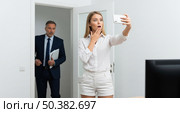 Shocked manager catching lazy worker making self-portrait on her phone, this funny scene shows social media addiction. Стоковое AI-изображение, AI-художник Павел Муравьев / Фотобанк Лори