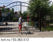 Мужчина везет в тележке бутыль с водой для кулера. Редакционное фото, фотограф Евгений Будюкин / Фотобанк Лори