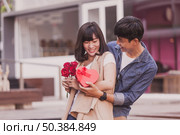 man handing gift roses woman. Стоковое фото, агентство Ingram Publishing / Фотобанк Лори