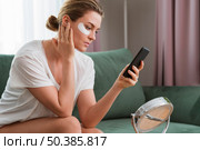 woman wearing eye mask patches using mobile phone. Стоковое фото, агентство Ingram Publishing / Фотобанк Лори