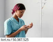 medium shot woman adjusting perfusion. Стоковое фото, агентство Ingram Publishing / Фотобанк Лори