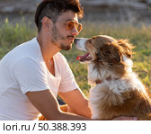 side view young man with dog seaside. Стоковое фото, агентство Ingram Publishing / Фотобанк Лори
