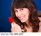 Beautiful young woman holding and showing a big and fresh strawberry. Стоковое фото, агентство Ingram Publishing / Фотобанк Лори