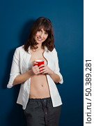 Beautiful young woman wearing a casual lingerie against a blue wall, and drinking coffee. Стоковое фото, агентство Ingram Publishing / Фотобанк Лори