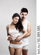 Beautiful and attractive young couple standing over a white background. Стоковое фото, агентство Ingram Publishing / Фотобанк Лори