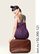 Portrait of a beautiful woman with a vintage style sitting over the baggage. Стоковое фото, агентство Ingram Publishing / Фотобанк Лори