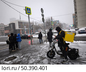 Курьер на электровелосипеде в городе. Редакционное фото, фотограф Мария Сергеева / Фотобанк Лори