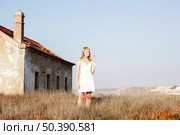 Beautiful young woman in a meadow wearing a crown of flowers. Стоковое фото, агентство Ingram Publishing / Фотобанк Лори