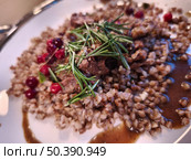 Гречневая каша с мясом, розмарином и ягодами клюквы на тарелке. Стоковое фото, фотограф Мария Сергеева / Фотобанк Лори