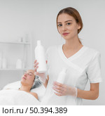 beautician with lotion female client. Стоковое фото, агентство Ingram Publishing / Фотобанк Лори
