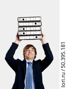 Young business man carrying a bunch of folders. Стоковое фото, агентство Ingram Publishing / Фотобанк Лори