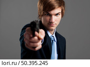 Stressed businessman holding and pointing a gun to the camera. Стоковое фото, агентство Ingram Publishing / Фотобанк Лори