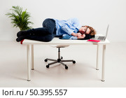Young man in the office and sleeping over is desk. Стоковое фото, агентство Ingram Publishing / Фотобанк Лори
