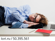 Young man in the office and sleeping over is desk. Стоковое фото, агентство Ingram Publishing / Фотобанк Лори
