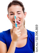 Beautiful woman with funny face holding toothbrush, isolated over a white background. Стоковое фото, агентство Ingram Publishing / Фотобанк Лори