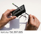 person repairing black cassette tape with pencil. Стоковое фото, агентство Ingram Publishing / Фотобанк Лори
