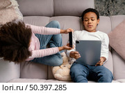 siblings using tablet mobile home 4. Стоковое фото, агентство Ingram Publishing / Фотобанк Лори