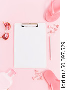 white paper clipboard surrounded with miniature luggage bag sunglasses paperclips pencil flip flops pink background. Стоковое фото, агентство Ingram Publishing / Фотобанк Лори