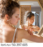 woman looking mirror applying cream hands 2. Стоковое фото, агентство Ingram Publishing / Фотобанк Лори