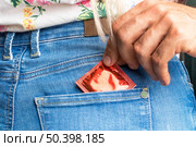 close up man putting condom pocket. Стоковое фото, агентство Ingram Publishing / Фотобанк Лори