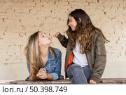 happy young girl touching bubble blown by her friend with chewing gum. Стоковое фото, агентство Ingram Publishing / Фотобанк Лори