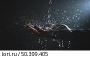 Water Stream Pouring onto Male Palm Against Black Background with Backlight. Стоковое видео, видеограф Илья Шаматура / Фотобанк Лори