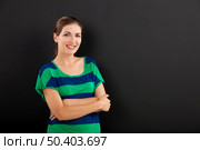 Happy woman in front of a chalkboard with copy space for designer. Стоковое фото, агентство Ingram Publishing / Фотобанк Лори