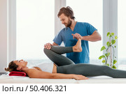 front view osteopathic therapist checking female patient s leg movement. Стоковое фото, агентство Ingram Publishing / Фотобанк Лори