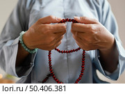 front view woman holding beads meditating. Стоковое фото, агентство Ingram Publishing / Фотобанк Лори