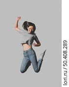 front view happy woman jumping air. Стоковое фото, агентство Ingram Publishing / Фотобанк Лори