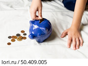 blue piggy bank filled with coins. Стоковое фото, агентство Ingram Publishing / Фотобанк Лори