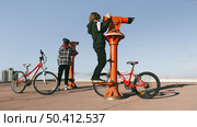 boys with bicycles looking through telescopes outdoors. Стоковое фото, агентство Ingram Publishing / Фотобанк Лори