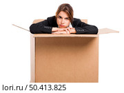 Stressed business woman appear inside a big card box, isolated over white background . Стоковое фото, агентство Ingram Publishing / Фотобанк Лори