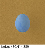 Blue painted egg on yellow background. Стоковое фото, агентство Ingram Publishing / Фотобанк Лори