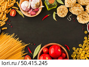 various type raw pasta with ingredients black backdrop. Стоковое фото, агентство Ingram Publishing / Фотобанк Лори