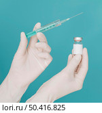 vaccine bottle syringe held by hands with gloves. Стоковое фото, агентство Ingram Publishing / Фотобанк Лори