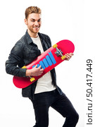 Studio portrait of a young man posing with a skateboard. Стоковое фото, агентство Ingram Publishing / Фотобанк Лори
