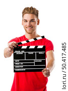 Portrait of a handsome young man wolding a clapboard. Стоковое фото, агентство Ingram Publishing / Фотобанк Лори