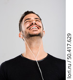 Portrait of latin man smiling and listen music . Стоковое фото, агентство Ingram Publishing / Фотобанк Лори