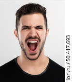 Studio portrait of a handsome young man yelling. Стоковое фото, агентство Ingram Publishing / Фотобанк Лори
