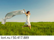 Young beautiful woman running while holding a white tissue. Стоковое фото, агентство Ingram Publishing / Фотобанк Лори