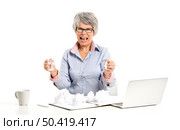 Stressed elderly woman working in the office with a laptop. Стоковое фото, агентство Ingram Publishing / Фотобанк Лори
