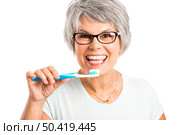 Portrait of a happy old woman brushing her teeth. Стоковое фото, агентство Ingram Publishing / Фотобанк Лори