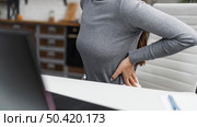 businesswoman having backache while working from home. Стоковое фото, агентство Ingram Publishing / Фотобанк Лори